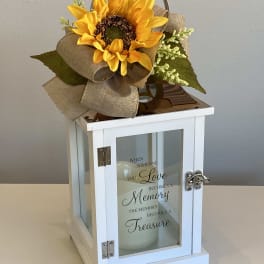 Sunflower arrangement on a white lantern with a memorial quote