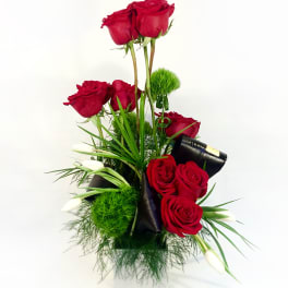 Tall arrangement of red roses with white calla lilies in a vase