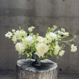 White floral arrangement in a low pedestal vase