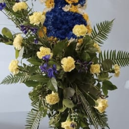 Tall floral standing spray in blue, yellow, and white flowers
