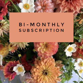 Mixed flowers behind a bi-monthly subscription card