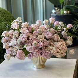 Pink and blush roses with hydrangeas in a cream vase