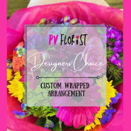 Wrapped bouquet of mixed pink, purple, and yellow flowers
