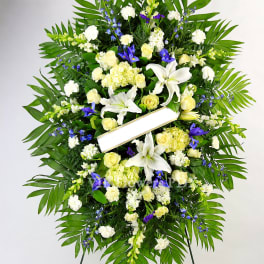 Large standing funeral wreath with white lilies and pale yellow roses