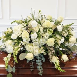 White floral casket spray with roses and mixed blooms