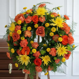 Orange and yellow floral wreath on a wooden stand