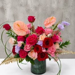 Mixed roses and anthuriums in a green vase