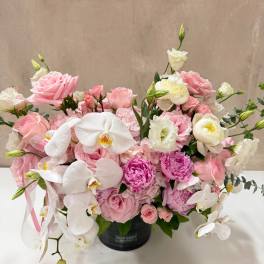 Pink and white floral arrangement in a black vase