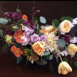 Colorful bouquet with roses, tulips, and mixed blooms in a low vase