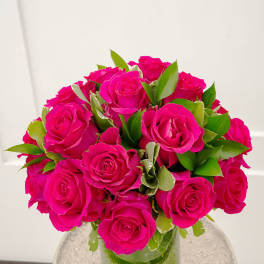 Bouquet of bright pink roses in a clear glass vase