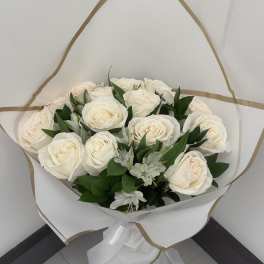 Bouquet of white roses with small white filler flowers wrapped in white paper