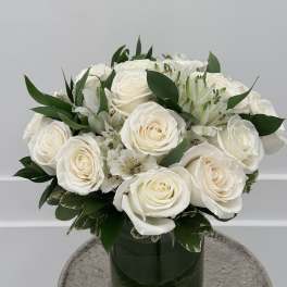White roses and alstroemeria arranged in a green glass vase