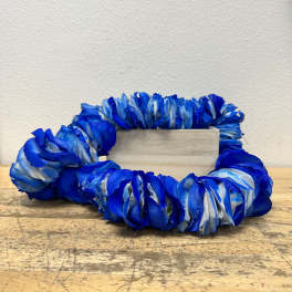 Blue floral wreath around a small wooden block