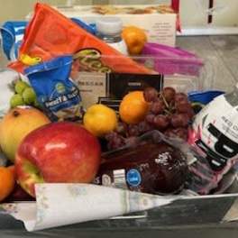 Gift basket with assorted fruit and packaged snacks