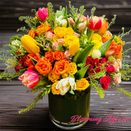 Colorful bouquet of tulips and roses in a glass vase