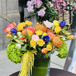 Colorful mixed flower arrangement in a square glass vase