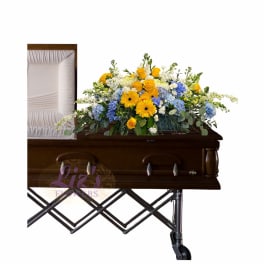 Casket spray with yellow, blue, and white flowers