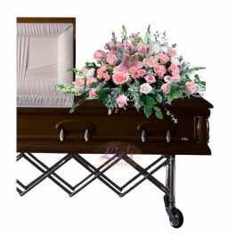 Pink floral casket spray with roses and lilies