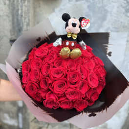 Bouquet of red roses topped with a small Mickey Mouse plush