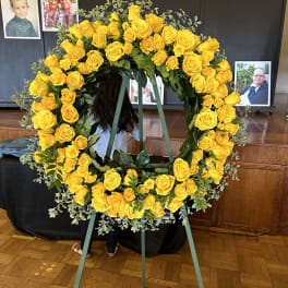 Large yellow rose funeral wreath on a standing easel