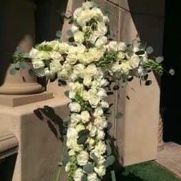 White rose cross arrangement with eucalyptus