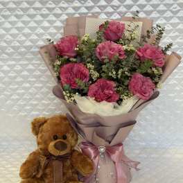 Pink rose bouquet with a teddy bear and satin ribbon