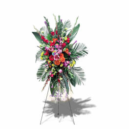 Tall standing floral spray with bright mixed blooms on a metal easel