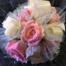 Pink roses with white ribbon and tulle in a black container