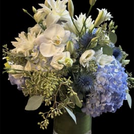 White and blue floral arrangement in a glass vase