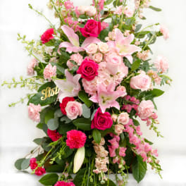 Tall pink floral arrangement with roses and lilies