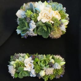 Two succulent floral arrangements with cream roses on a black background