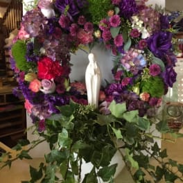 Purple floral wreath with a white statue in the center