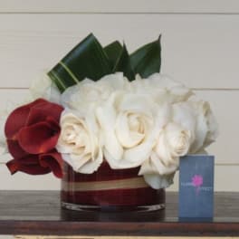 White and red roses arranged in a low glass vase