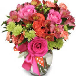 Pink and orange mixed bouquet in a glass vase with a ribbon