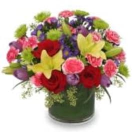 Colorful mixed bouquet in a dark vase with red, pink, purple, and yellow flowers