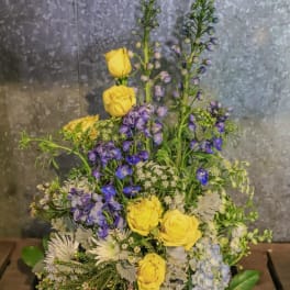 Yellow roses and blue-purple flowers in a mixed arrangement