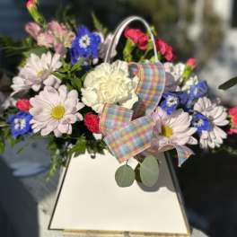 Mixed bouquet with daisies, carnations, and a plaid ribbon in a white box