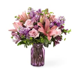 Pink and purple bouquet in a purple glass vase