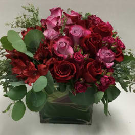 Bouquet of red and pink roses in a square glass vase
