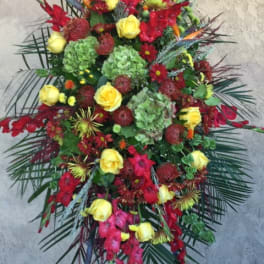 Tall standing floral spray with red and yellow flowers on a black easel