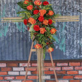 Tall floral standing arrangement with orange roses and red carnations on an easel
