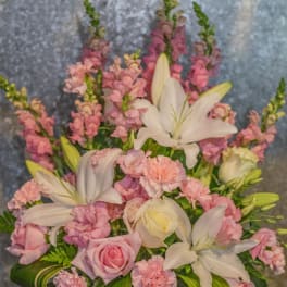 Pink and white floral arrangement with lilies and roses in a vase