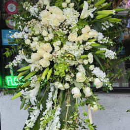 Large white floral standing spray on a wooden easel