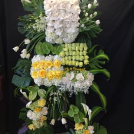 Large floral standing arrangement with white and yellow roses and calla lilies