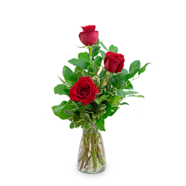 Three red roses in a clear glass vase