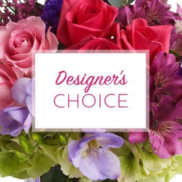 Mixed bouquet of pink and purple flowers with a "Designer’s Choice" card