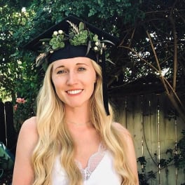 Woman wearing a black graduation cap decorated with succulents