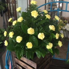 Yellow carnations in a wooden crate arrangement