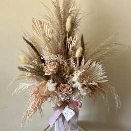 Dried floral arrangement with blush roses in a white vase