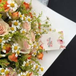 Bouquet of pale pink roses and white daisies with orange accents